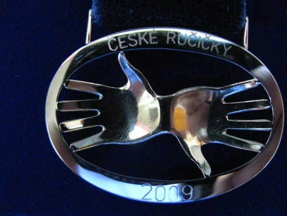 Oválná plaketa s dlaněmi a nápisem České ručičky 2009